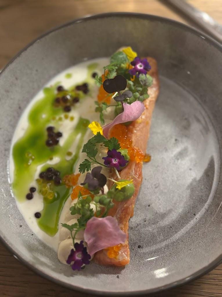 A plate of food with flowers

AI-generated content may be incorrect.