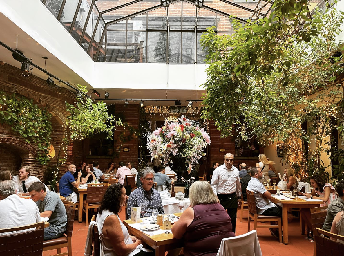 A group of people sitting at tables in a restaurant

AI-generated content may be incorrect.